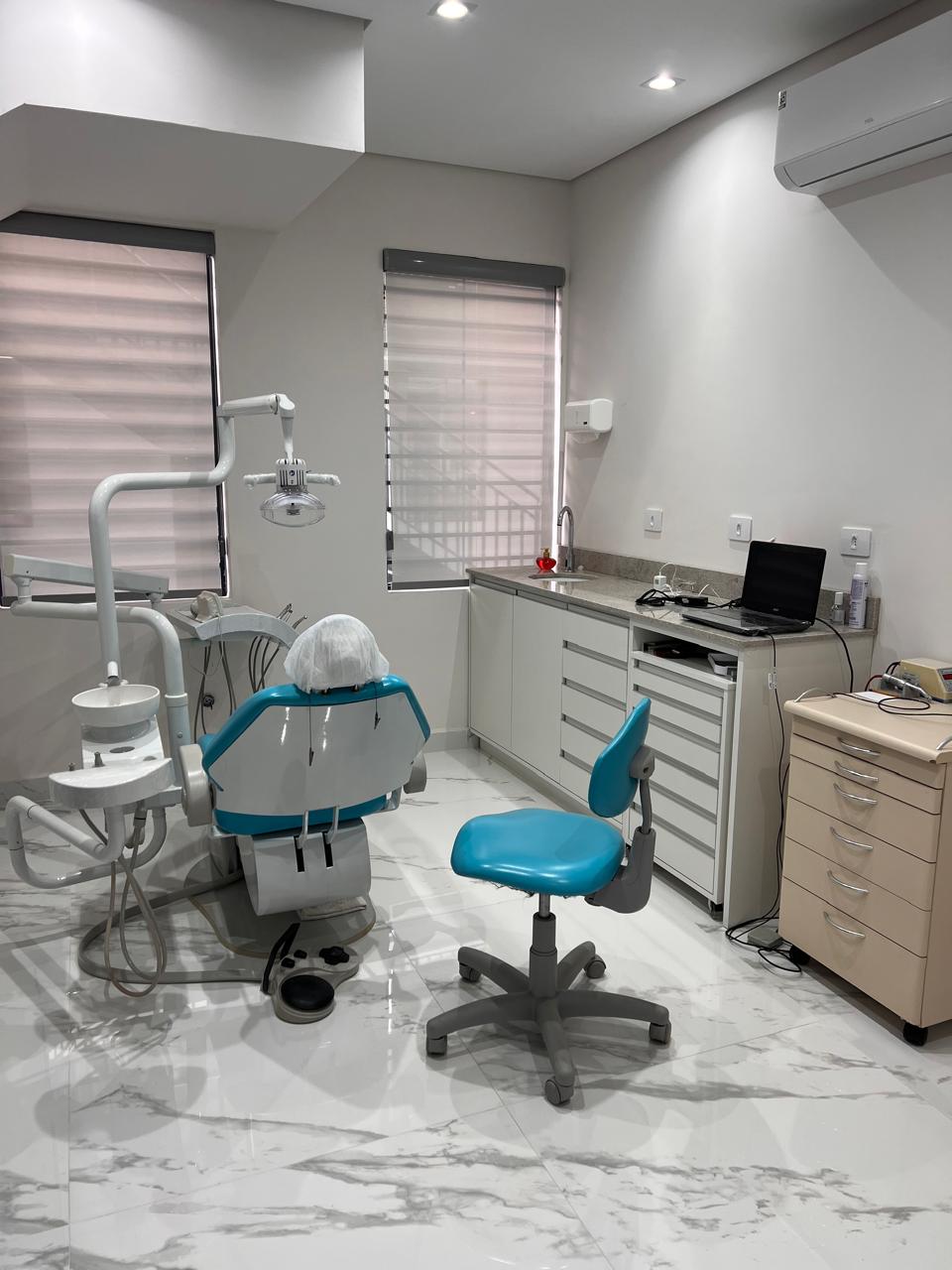 Consultório odontológico equipado com cadeira e equipamentos modernos